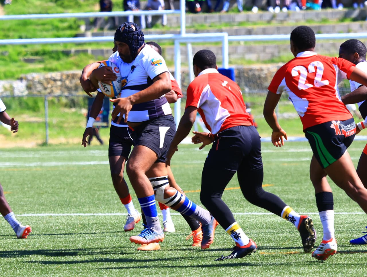 A ball carrier moves forward as other players approach.